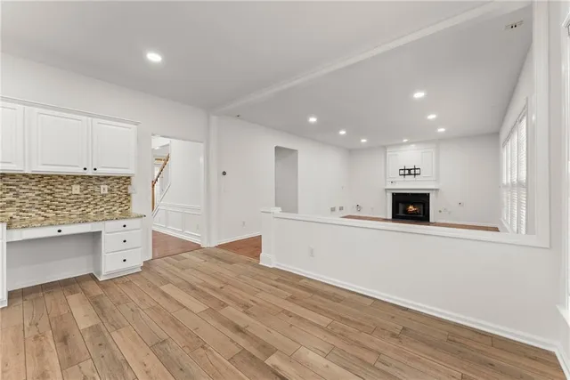 a large white kitchen with wooden floors and white cabinets