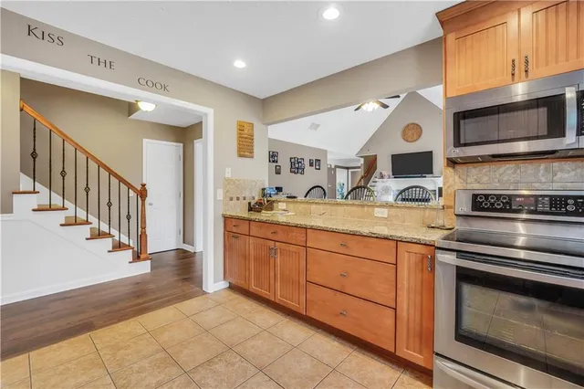 a kitchen with stainless steel appliances granite countertop a refrigerator and a sink