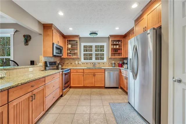 a kitchen with stainless steel appliances granite countertop a refrigerator and a sink