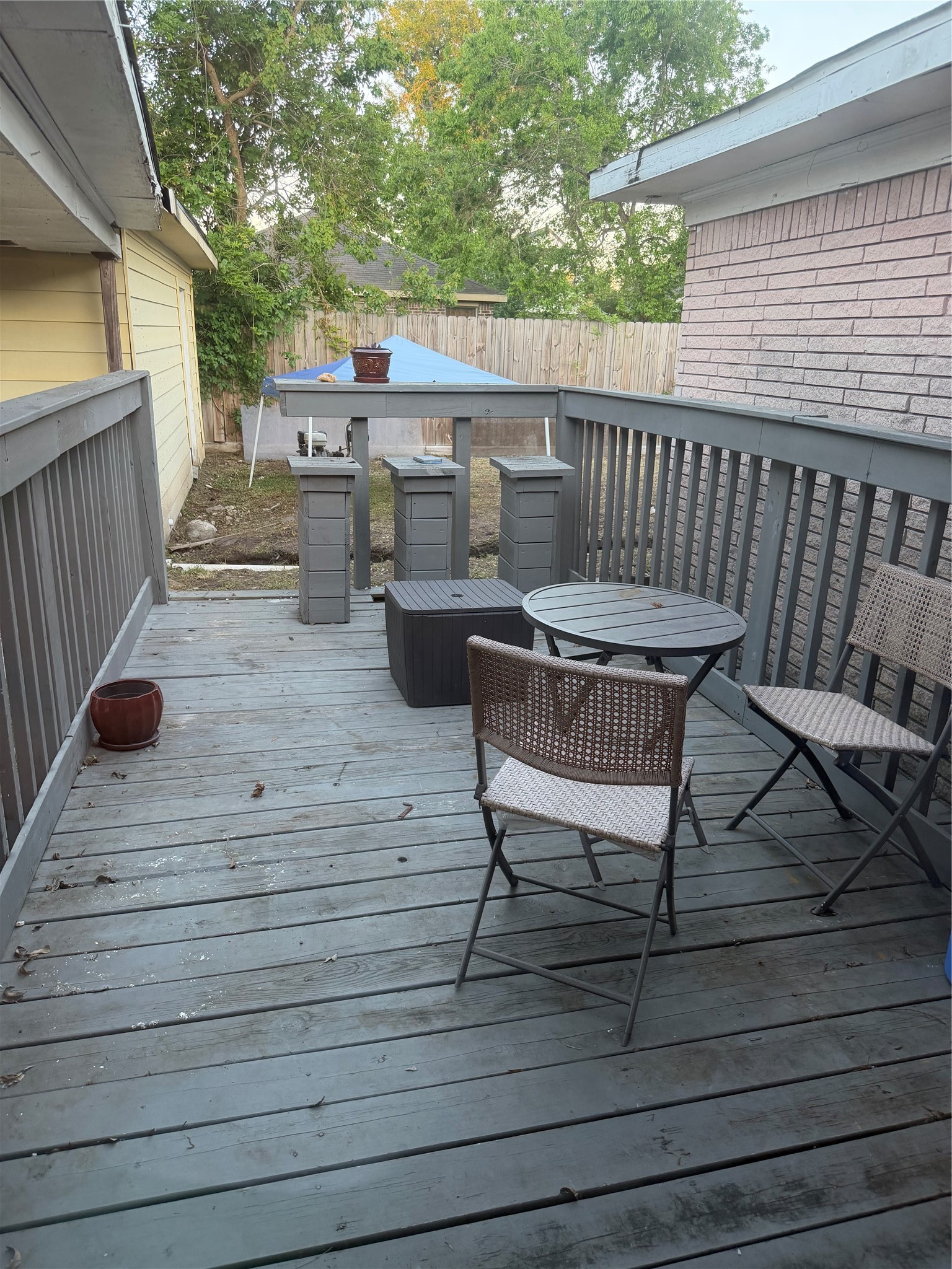 6811 St Augustine Street Houston, TX 77021 - Photo 19 of 20 a view of a roof deck with table and chairs a barbeque with wooden floor and fence