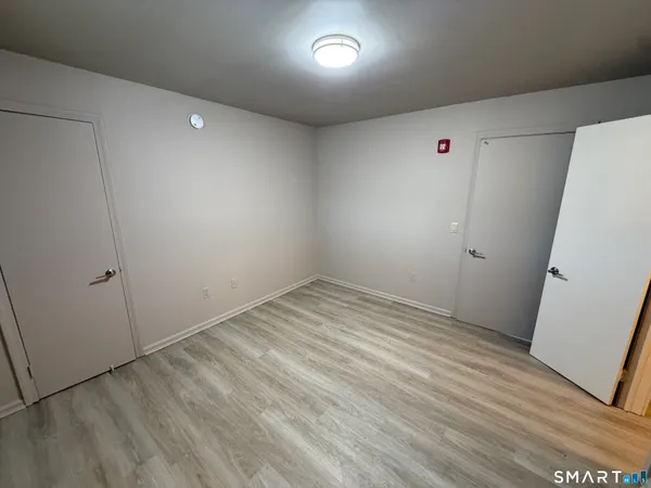 a view of empty room with wooden floor