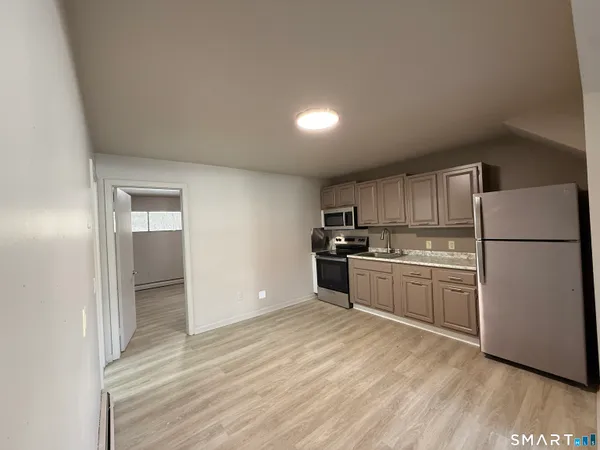 a kitchen with a refrigerator and a stove top oven