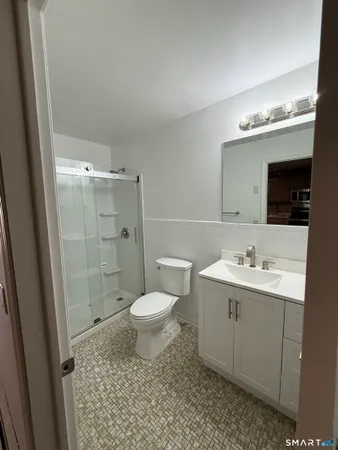 a bathroom with a sink toilet a mirror and shower