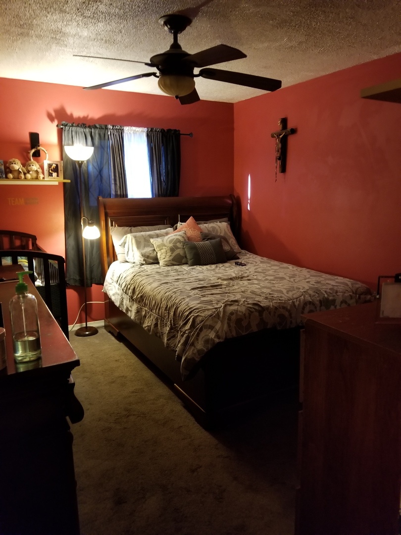 181 Oxford Road Bolingbrook, IL 60440 - Photo 22 of 29 a bedroom with a bed and a chandelier