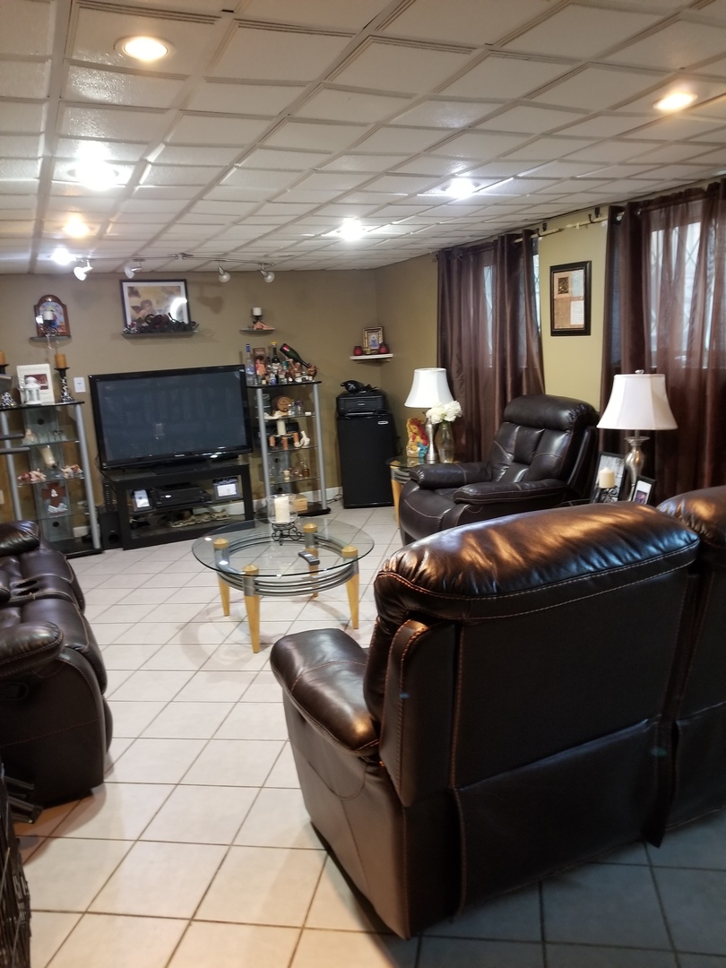 181 Oxford Road Bolingbrook, IL 60440 - Photo 10 of 29 a living room with furniture a flat screen tv and a lamp