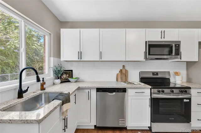 a kitchen with sink a microwave and stove top oven