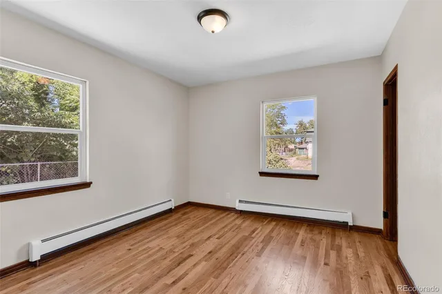 a view of a room with wooden floors and window