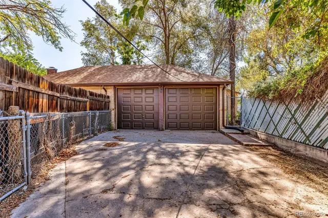 a view of a house with a small yard and a large tree