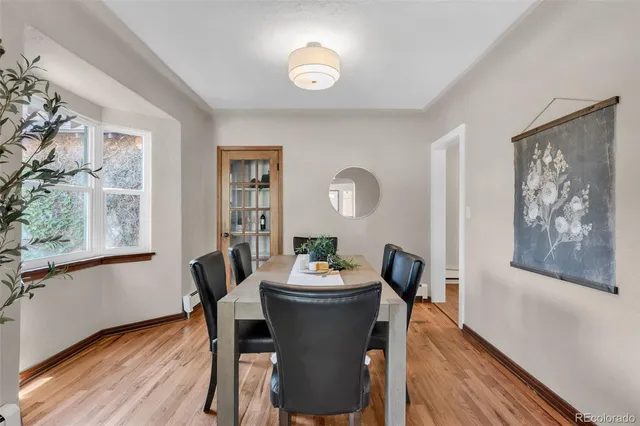 a dining room with furniture a window and wooden floor