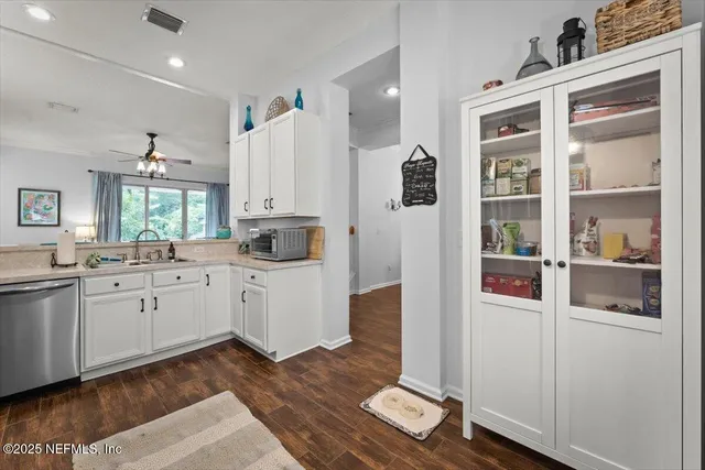 a kitchen with a refrigerator and white cabinets