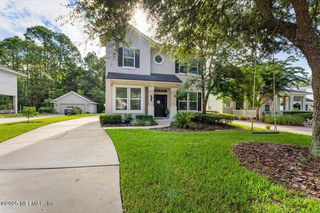 a view of a house with a yard and palm trees