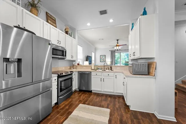 a kitchen with white cabinets and stainless steel appliances