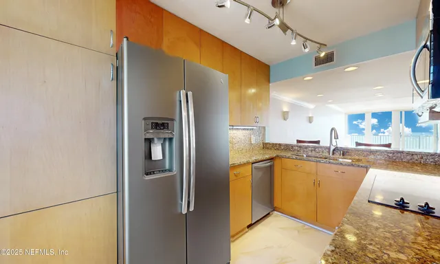 a kitchen with granite countertop a sink a stove and cabinets