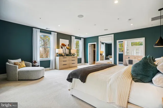 a spacious bedroom with a bed and glass walk in closet