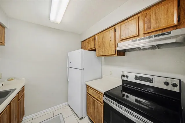 a kitchen with wooden cabinets and a stove top oven