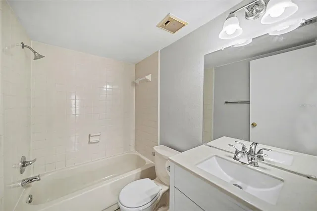 a bathroom with a bathtub shower sink vanity and toilet