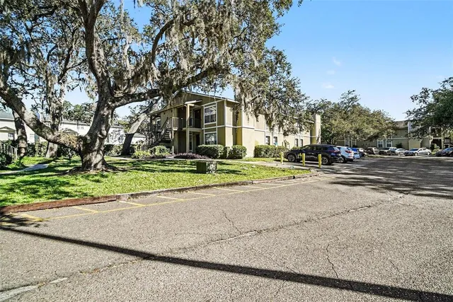 a front view of a house with a yard and trees