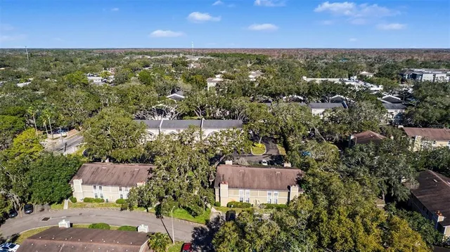 an aerial view of residential house with outdoor space and trees all around