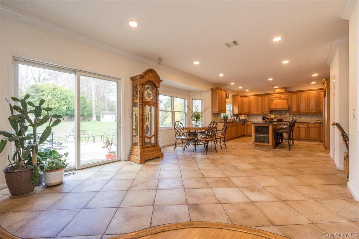 129 Round Swamp Road Huntington, NY 11743 - Photo 13 of 50 Very large eat-in kitchen with tile flooring, wood cabinetry, stone countertops and tile backsplash. Decorative crown and baseboard moldings with recessed lighting.