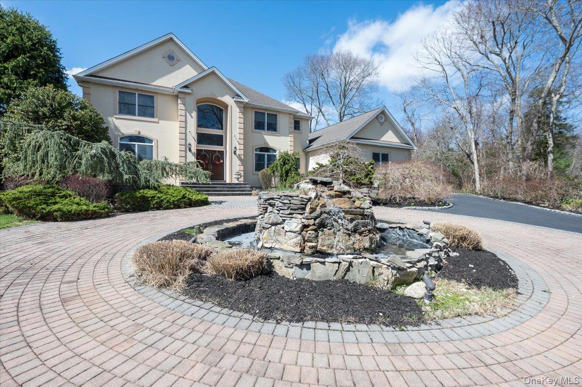 129 Round Swamp Road Huntington, NY 11743 - Photo 2 of 50 View of front of property with a garden pond, stucco siding, and curved driveway