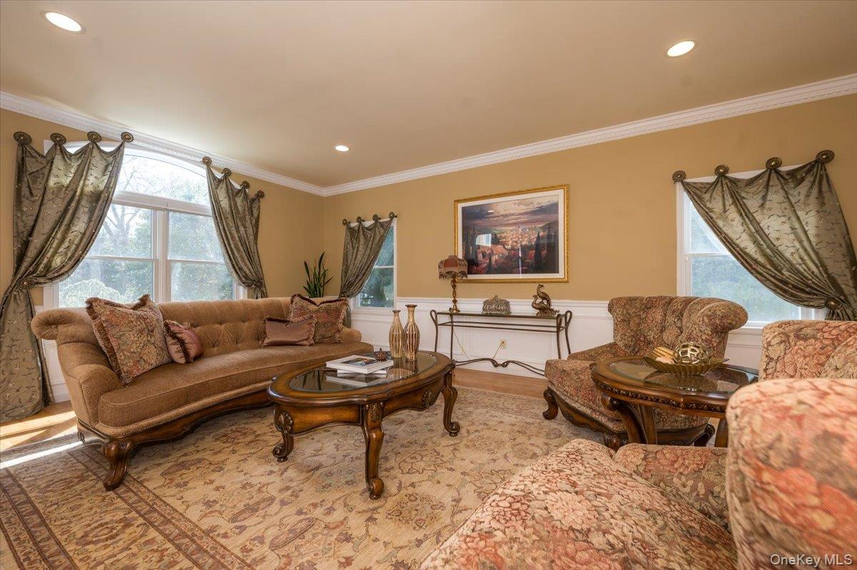 129 Round Swamp Road Huntington, NY 11743 - Photo 7 of 50 Large room with hardwood floors, wainscoting, crown moldings and baseboard molding. Oversized windows let in plenty of natural light and recessed lighting keeps the space bright.