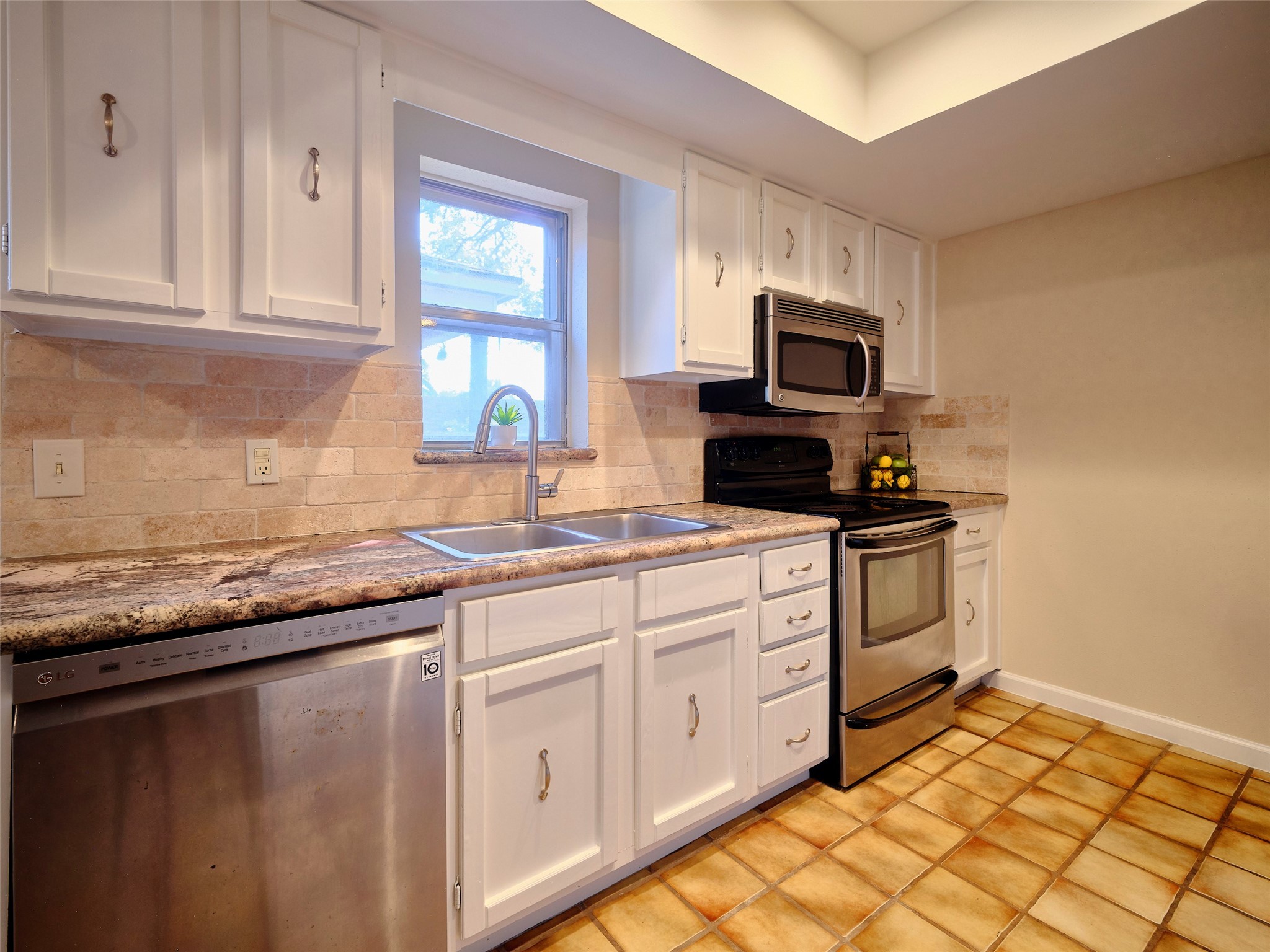 8315 Terrace Wind Lane Houston, TX 77040 - Photo 22 of 50 a kitchen with stainless steel appliances granite countertop a stove a sink and a microwave