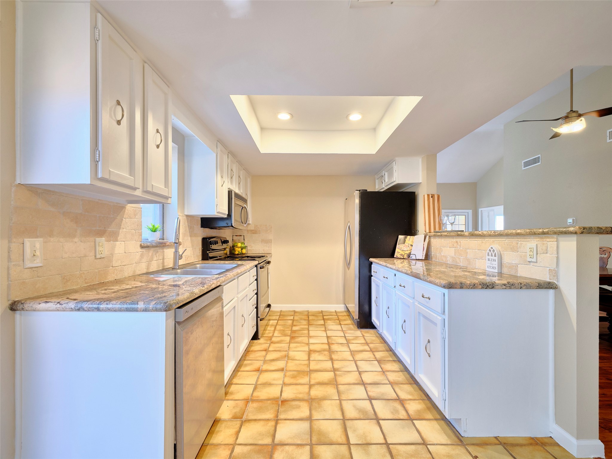 8315 Terrace Wind Lane Houston, TX 77040 - Photo 23 of 50 a large kitchen with granite countertop a sink and dishwasher a stove top oven with wooden floor