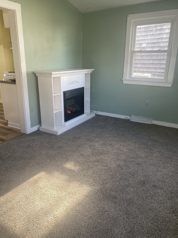 71 B Bay Street, Unit B Hull, MA 02045 - Photo 4 of 19 an empty room with a fireplace and a window