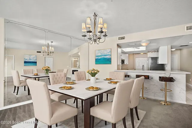 a view of a dining room with furniture and a chandelier