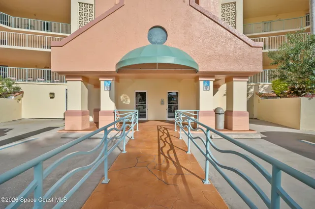 a view of a livingroom with a chandelier fan and windows