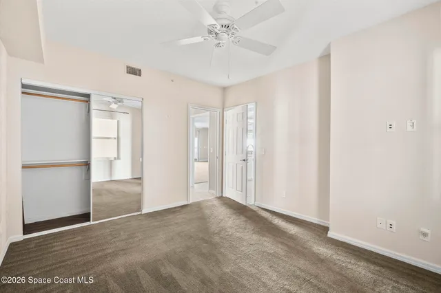 a view of an empty room with closet and a window
