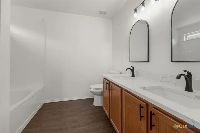 a bathroom with a sink and mirror with toilet