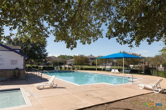 a view of a swimming pool and lounge chairs in patio