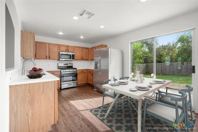 a kitchen with a table chairs stove and cabinets