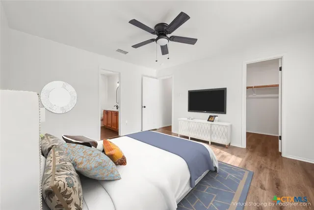 a bedroom with furniture a bed and a flat screen tv