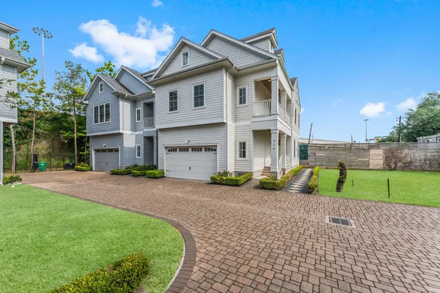 a view of a house with a small yard and a large tree