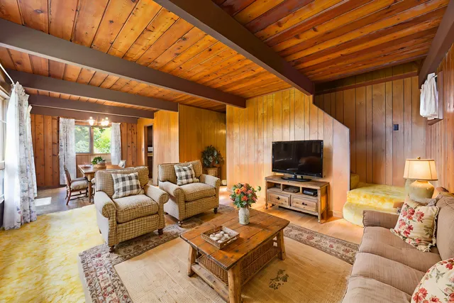 a living room with furniture a flat screen tv and a chandelier
