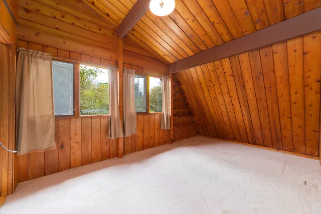 a bedroom with a bed and a dresser next to a window