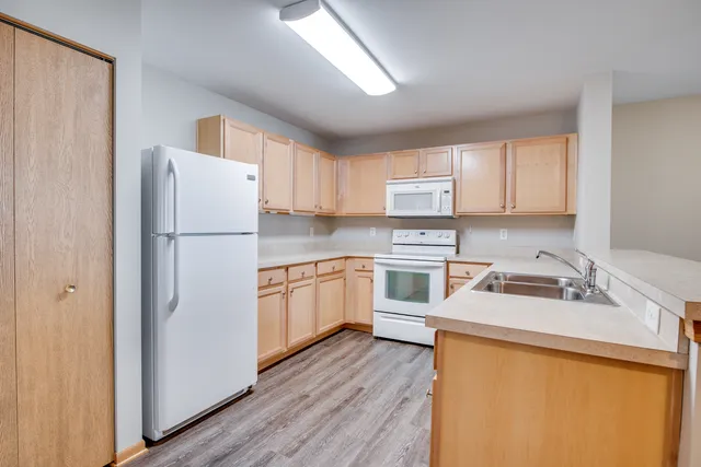 a kitchen with a sink a refrigerator and white cabinets