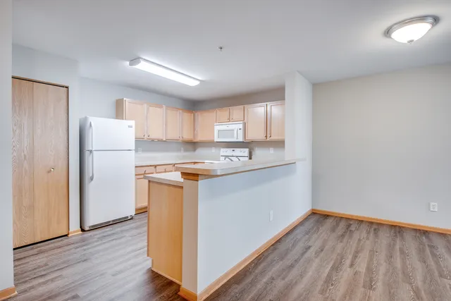 a kitchen with a refrigerator sink and cabinets