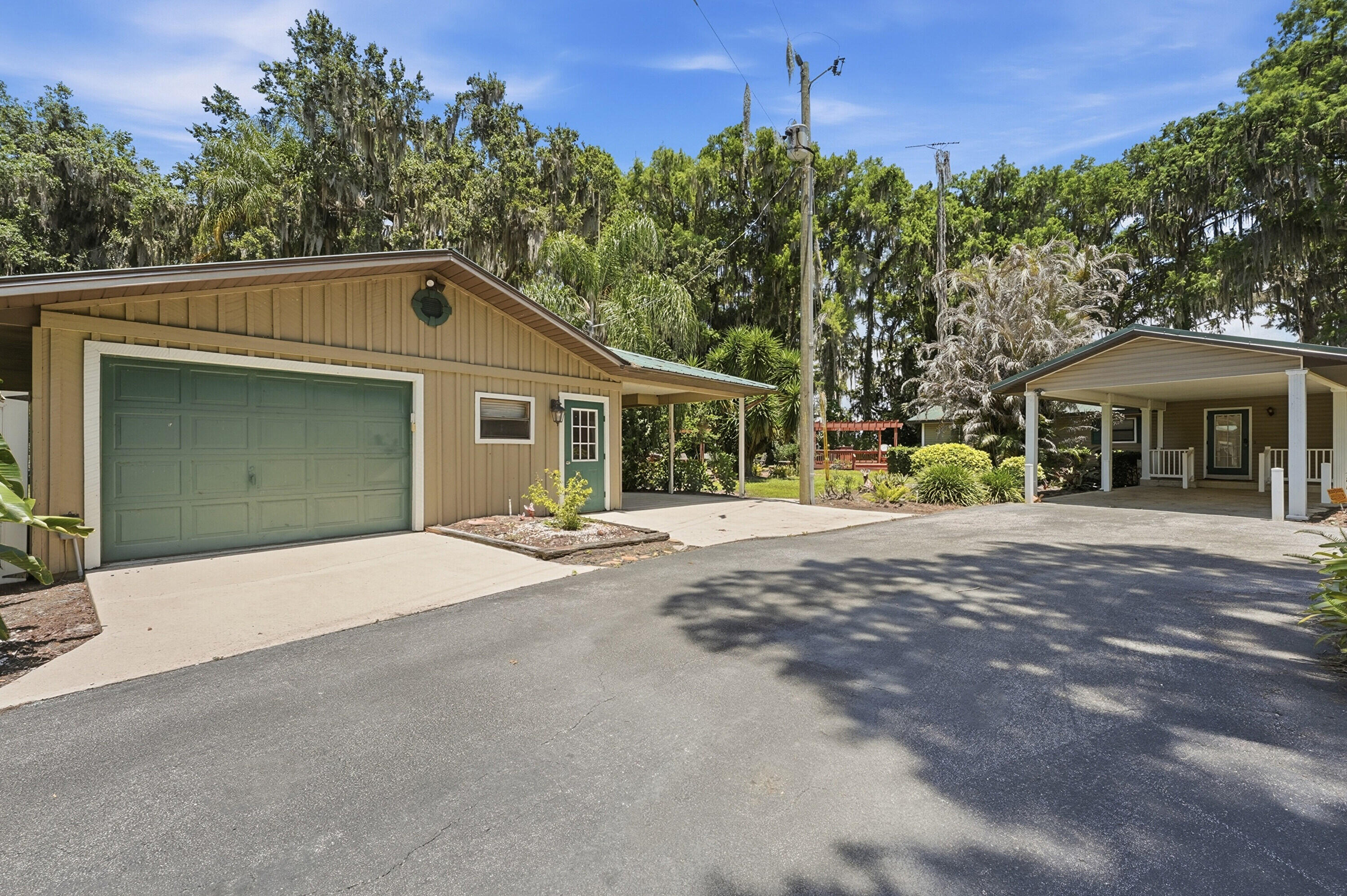 200 Windy Point Road Lake Placid, FL 33852 - Photo 50 of 74 a front view of a house with a garden and trees