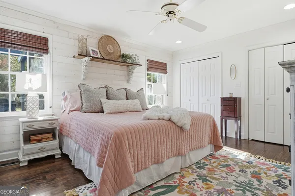 a bedroom with a bed a mirror and lamp