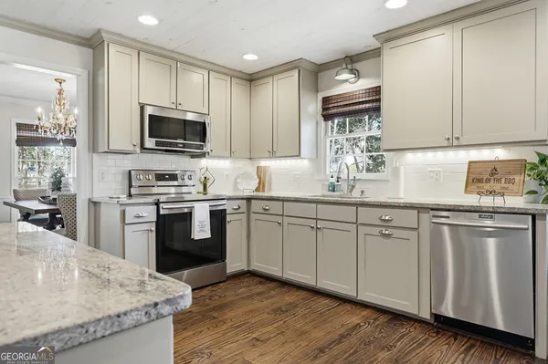 a kitchen with granite countertop cabinets stainless steel appliances and a sink