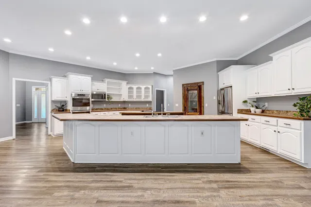 a view of a big room with windows and chandelier fan
