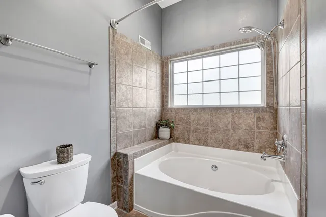 an empty room with wooden floor & windows and bathroom