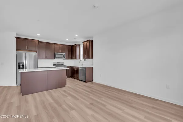 a large kitchen with kitchen island a sink stainless steel appliances and cabinets