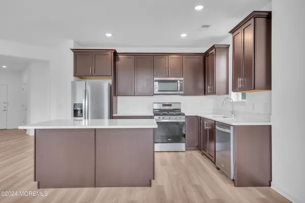 a kitchen with stainless steel appliances granite countertop a refrigerator sink and stove