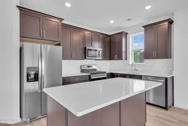 a kitchen with stainless steel appliances a refrigerator sink and microwave