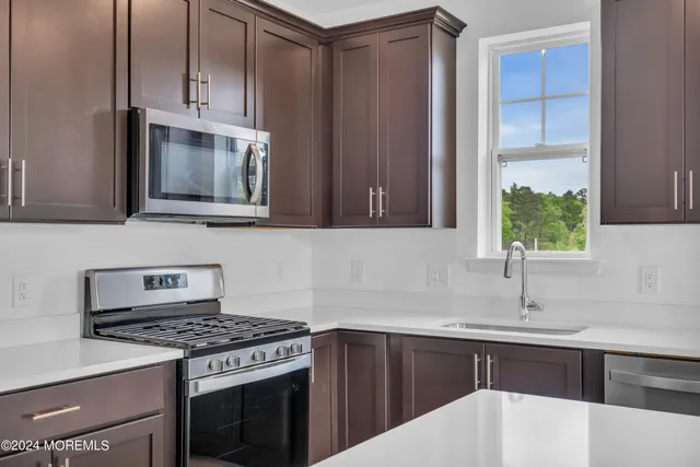 a kitchen with stainless steel appliances a stove a sink and a microwave