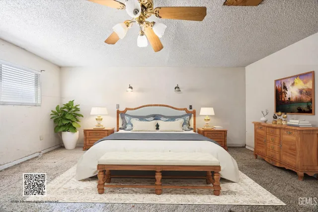 a bedroom with a bed a flat screen tv and potted plant